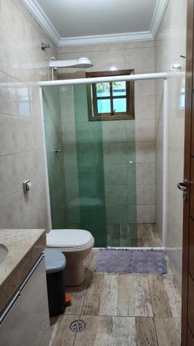 a bathroom with a toilet and a glass shower at Chacara Mairinque - Paraiso in Mairinque