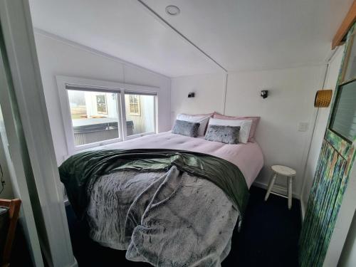 a bedroom with a large bed with a window at The Good Shepherds Hut in the NZ Dark Sky Reserve in Simons Pass