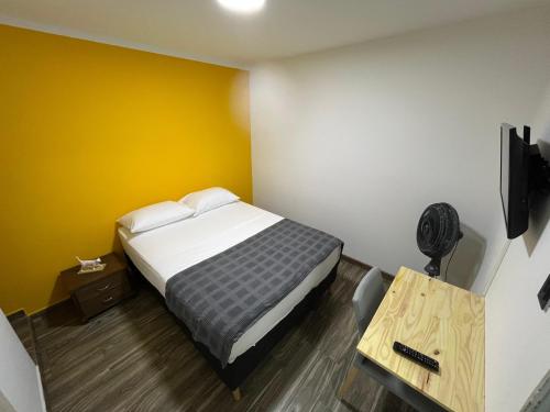 a bedroom with a bed and a desk and a television at Casa Vittoria in Cali