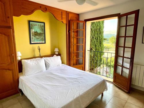 une chambre avec un lit et une grande fenêtre dans l'établissement La Pastorale, à Vidauban
