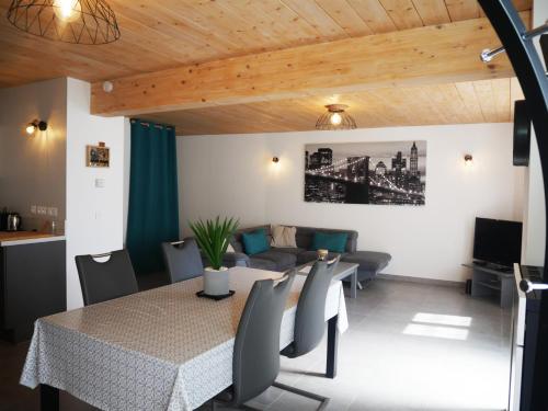 une salle à manger avec une table et un canapé dans l'établissement Maison de village Rives de L'Ain, à Serrières-sur-Ain