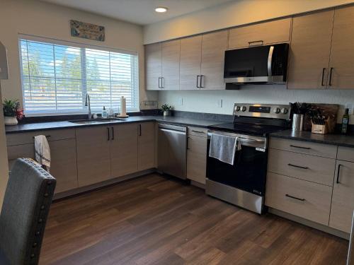 a kitchen with stainless steel appliances and wooden cabinets at Homestead Village - Two Bedroom Condo Ground Floor in Sandpoint
