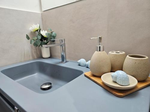 a sink with two cups and a vase on a counter at Marina Blu apartment by the sea in Altidona