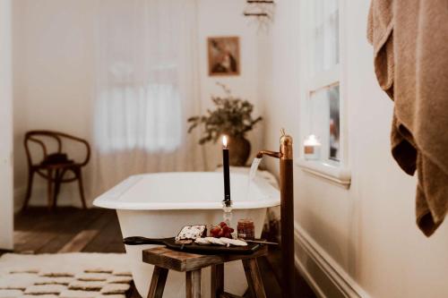 d'une baignoire avec une bougie. dans l'établissement The Postman's Cottage - Hinterland Luxury, à Montville