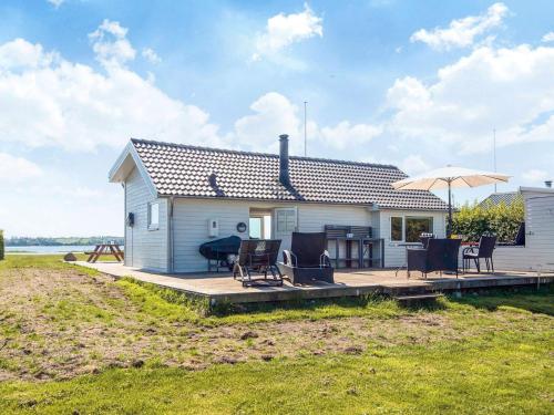 a house with a deck with chairs and an umbrella at 4 person holiday home in Aabenraa-By Traum in Aabenraa