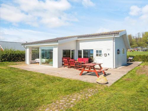 a picnic table in front of a white cottage at 4 person holiday home in Aabenraa-By Traum in Aabenraa