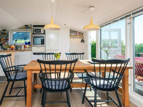 a kitchen and dining room with a wooden table and chairs at 4 person holiday home in Aabenraa-By Traum in Aabenraa