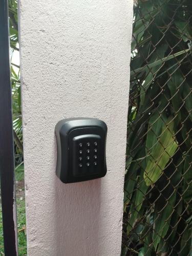 a black remote control on the side of a fence at Bungalow Domaine Kaliope in Le Robert