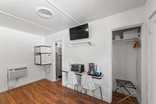 a white room with two chairs and a table in it at Atomic Motel in Moab