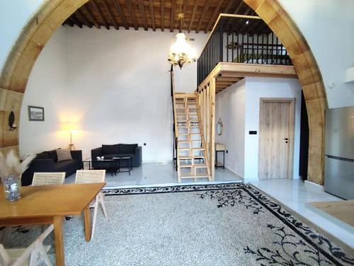 ein Wohnzimmer mit einem Torbogen und einer Treppe in der Unterkunft Lindos Central in Lindos