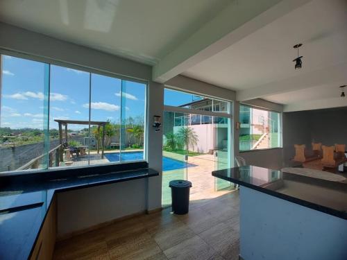 a large kitchen with a view of a swimming pool at Chacara Ibiuna - Incrivel in Ibiúna