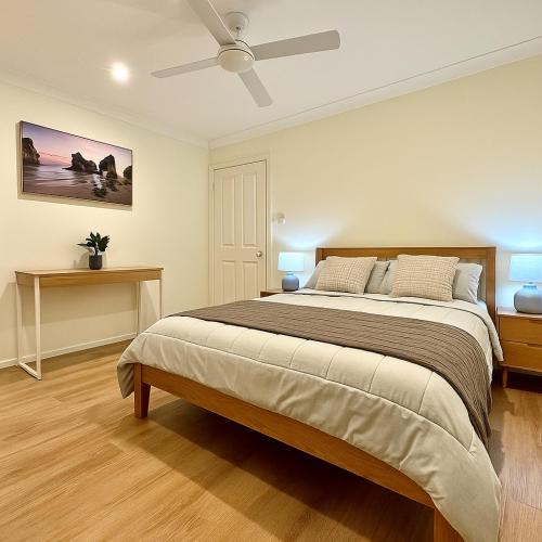 a bedroom with a large bed and a ceiling fan at Blue Horizon House with Private Pool. Pet Friendly in Nowra