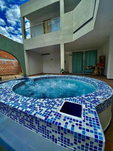 a large swimming pool with a blue and white tile design at El Encanto casa de descanso in Rivera