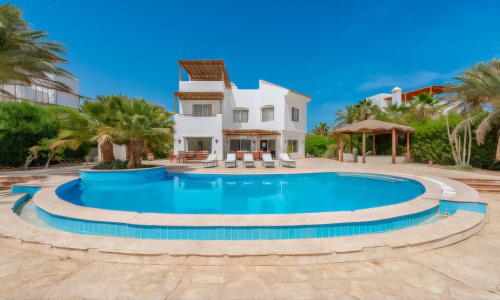 a swimming pool in front of a villa at Modern Villas in White Villas, El Gouna in Hurghada