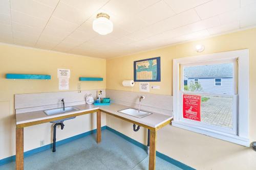 une salle de bain avec deux lavabos et une fenêtre dans l'établissement Anchorage Cottages #1, à Long Beach