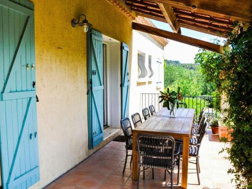 a patio with a wooden table and chairs on a balcony at Le Paradis in Cazedarnes