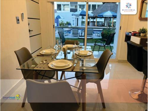 a dining room with a table and chairs and a view of a patio at Departamento nuevo en Manzanillo in Manzanillo