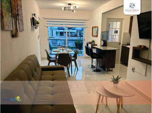 a living room and kitchen with a couch and a table at Departamento nuevo en Manzanillo in Manzanillo
