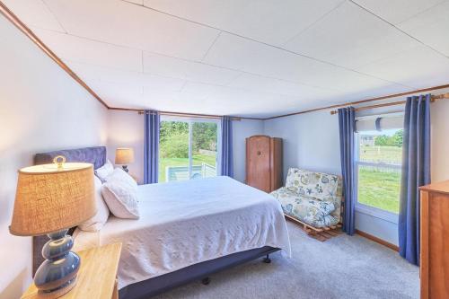 une chambre avec un lit, une chaise et une fenêtre dans l'établissement Anchorage Cottages #10, à Long Beach