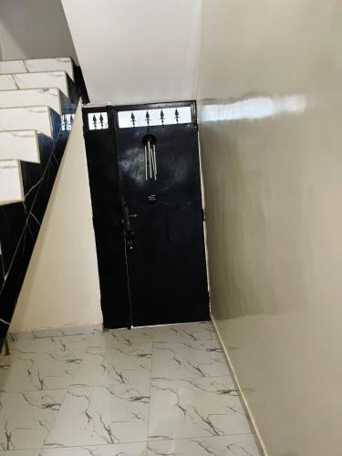 a black door in a room with marble floors at Mame Thierno sene in Niakoul Rap