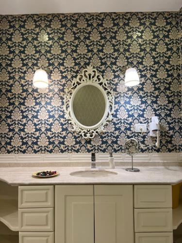a bathroom with a sink and a mirror at Luxury apartment in private compound in New Cairo in Banī Ghālib