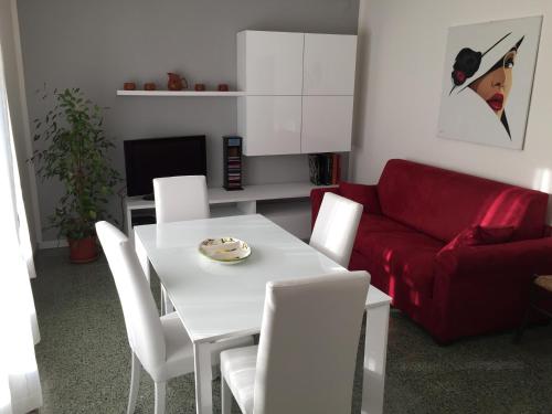 uma sala de estar com uma mesa branca e um sofá vermelho em Casa Romano em Pian del Voglio