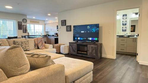 a living room with couches and a flat screen tv at Homestead Village - Two Bedroom Condo Balcony in Sandpoint