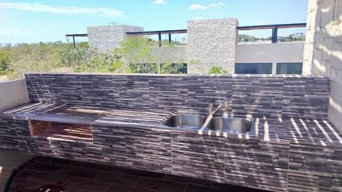 eine Küche mit einer Spüle in einer Ziegelwand in der Unterkunft Beautiful House in Playa del Carmen in Playa del Carmen