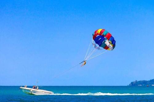 a person flying a kite over a boat in the ocean at AHLAN Dubai Marina JBR in Dubai