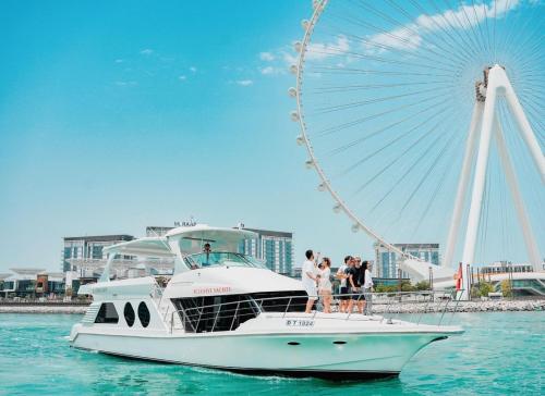 a boat in the water next to a ferris wheel at AHLAN Dubai Marina JBR in Dubai