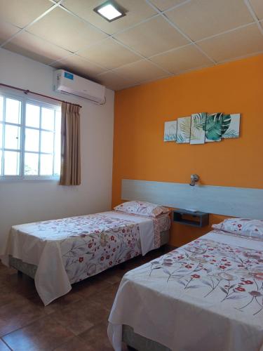 a hotel room with two beds and a window at Las Casuarinas in Federación