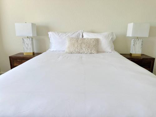 un lit blanc avec deux lampes dessus dans l'établissement Homestead Village - Two Bedroom Condo Top Floor, à Sandpoint