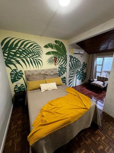 a bedroom with a bed with a yellow blanket on it at Tucan Hostel in Puerto Iguazú