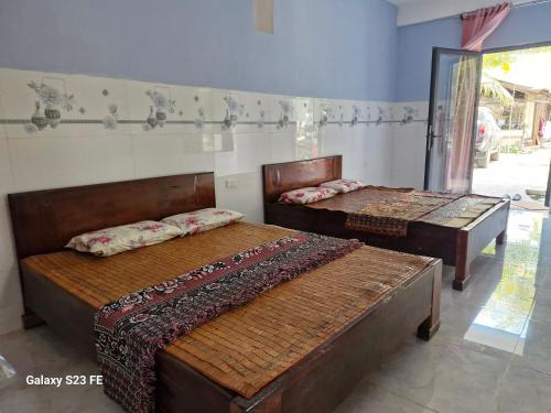 two beds in a room with two beds sidx sidx sidx at mekong floating market Nam Giang homestay in Cai Be