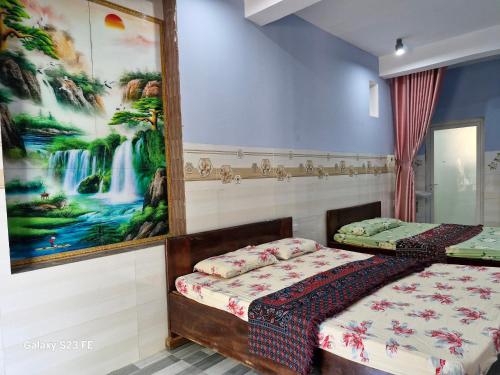 a bedroom with a bed and a painting on the wall at mekong floating market Nam Giang homestay in Cai Be