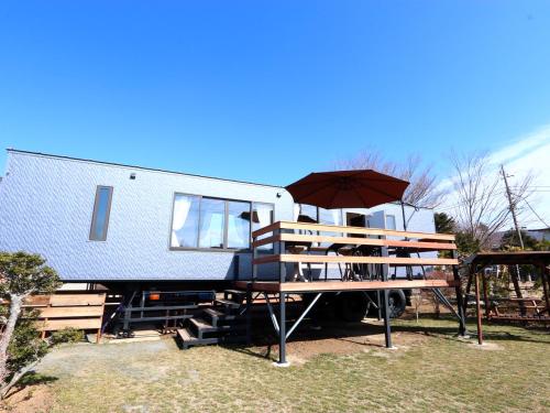 a blue and white trailer with an umbrella at Sugakuso in Yamanakako