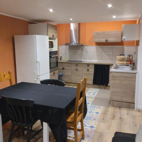 Il comprend une cuisine équipée d'une table noire et d'un réfrigérateur blanc. dans l'établissement House 20 minutes from Geneva & beaches, à Saint-Cergues