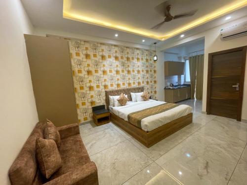 a bedroom with a bed and a couch at The Empire Stays , Golf Course Road in Gurgaon