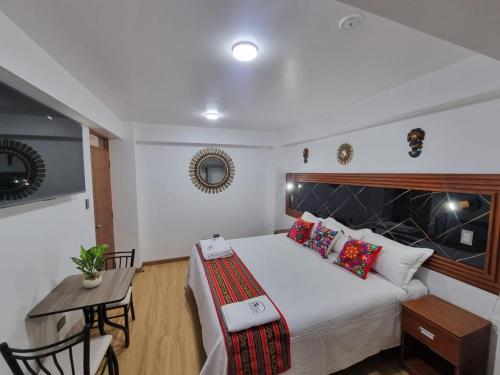 a bedroom with a bed and a table and a desk at Hotel Hatun Sumac Wasi in Sicuani