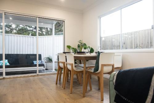 a dining room with a table and chairs and a large window at Retreat with horse stable views in Redcliffe