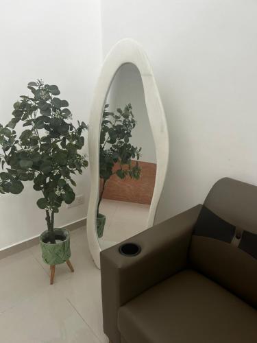 a living room with a couch and a mirror at Naura Homes Penang in Kampong Batu Maung