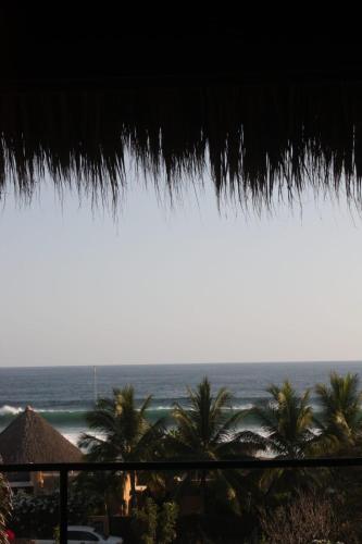 a view of the ocean from a straw umbrella at Casa Euskondido in Tlachicón