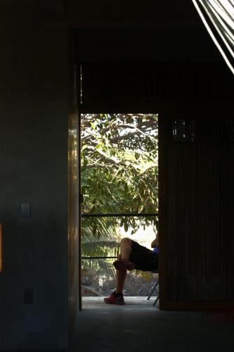 a person sitting in a chair looking out of a door at Casa Euskondido in Tlachicón