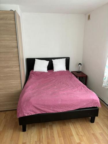 a bedroom with a bed with a pink blanket at Cavendish house in Strawberry Hill