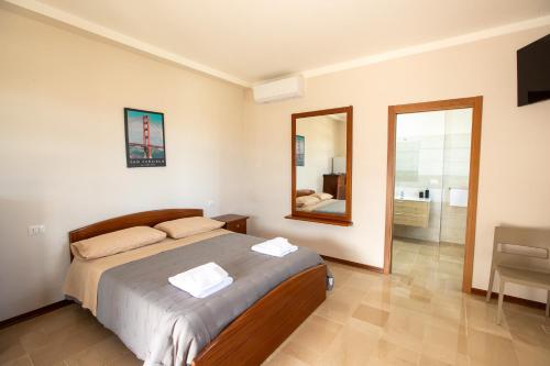 a bedroom with a large bed and a mirror at Il Rifugio del Principe in Gesualdo