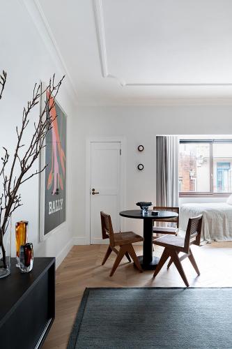 a living room with a table and chairs and a bed at Regents Court Sydney in Sydney