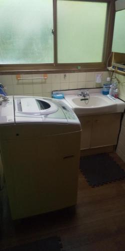 a bathroom with a sink and a large window at raibrasil guest house in Sanuki