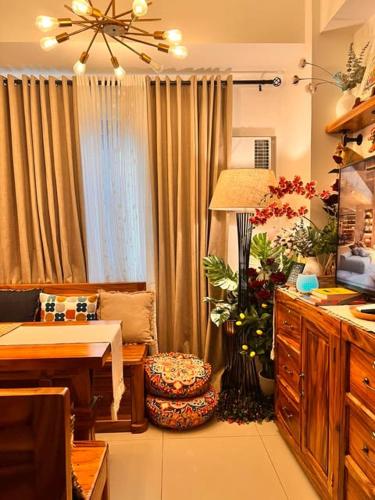 a living room with a table and a lamp and flowers at SMDC Green 2 Staycation, The Traditional & Modern Fusion Condo in Pasong Bayog