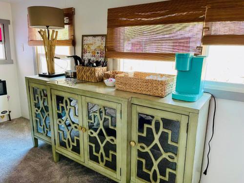 a wooden cabinet with some baskets on top of it at Sequoia Pine View Trailer Featured on HGTV in Wofford Heights