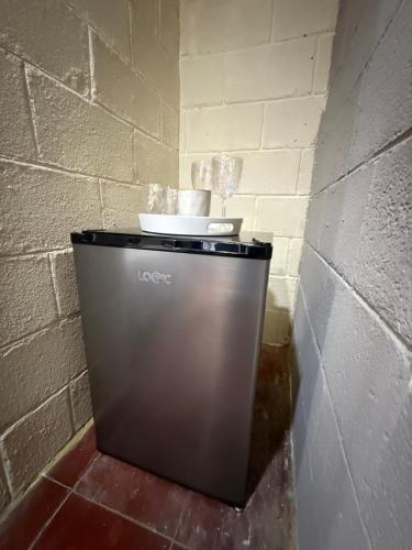 Un bote de basura en una esquina de una pared de ladrillos en Casa DUNA 4, en La Libertad